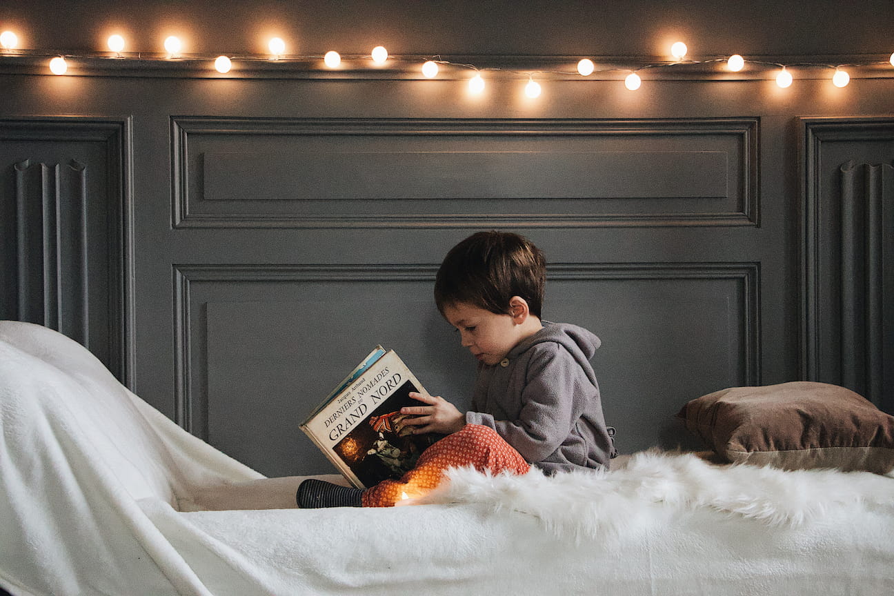 boy reading a book on his bed