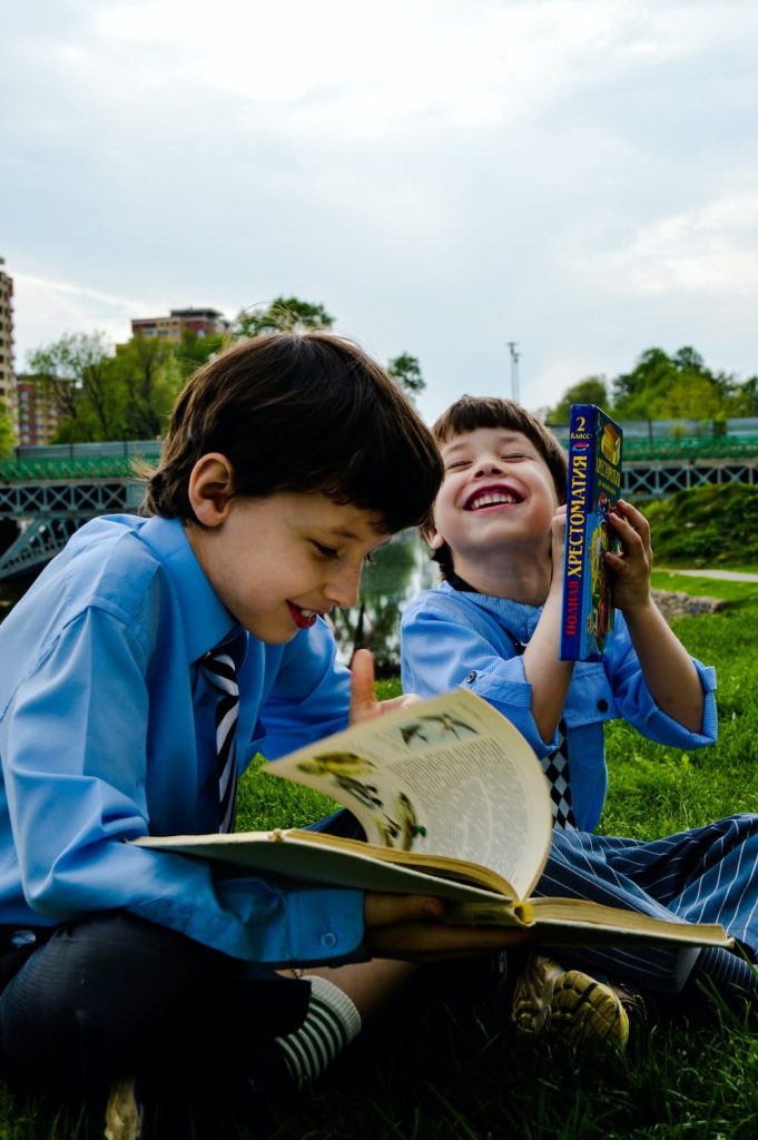 brothers having fun reading a book
